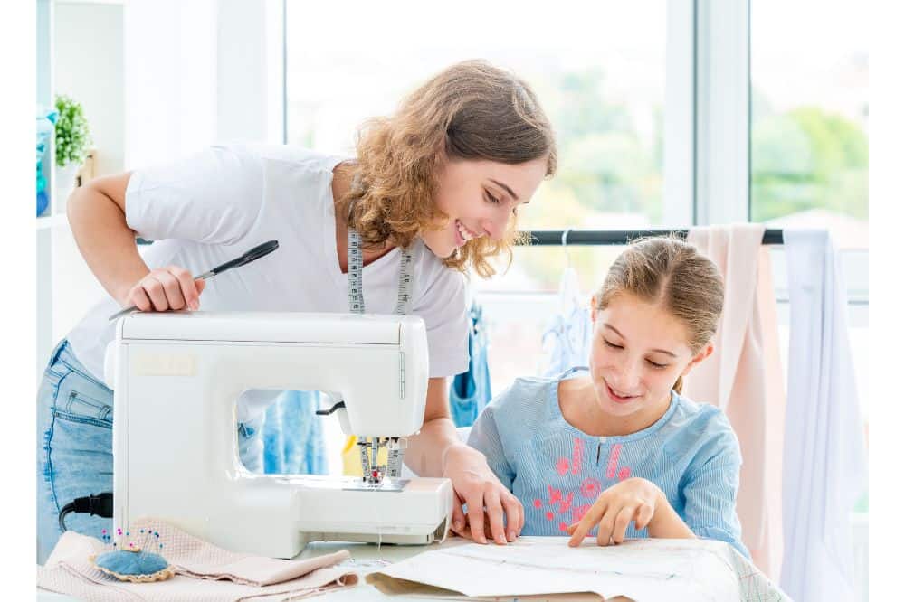 mother teaching her daughter how to use sewing machine