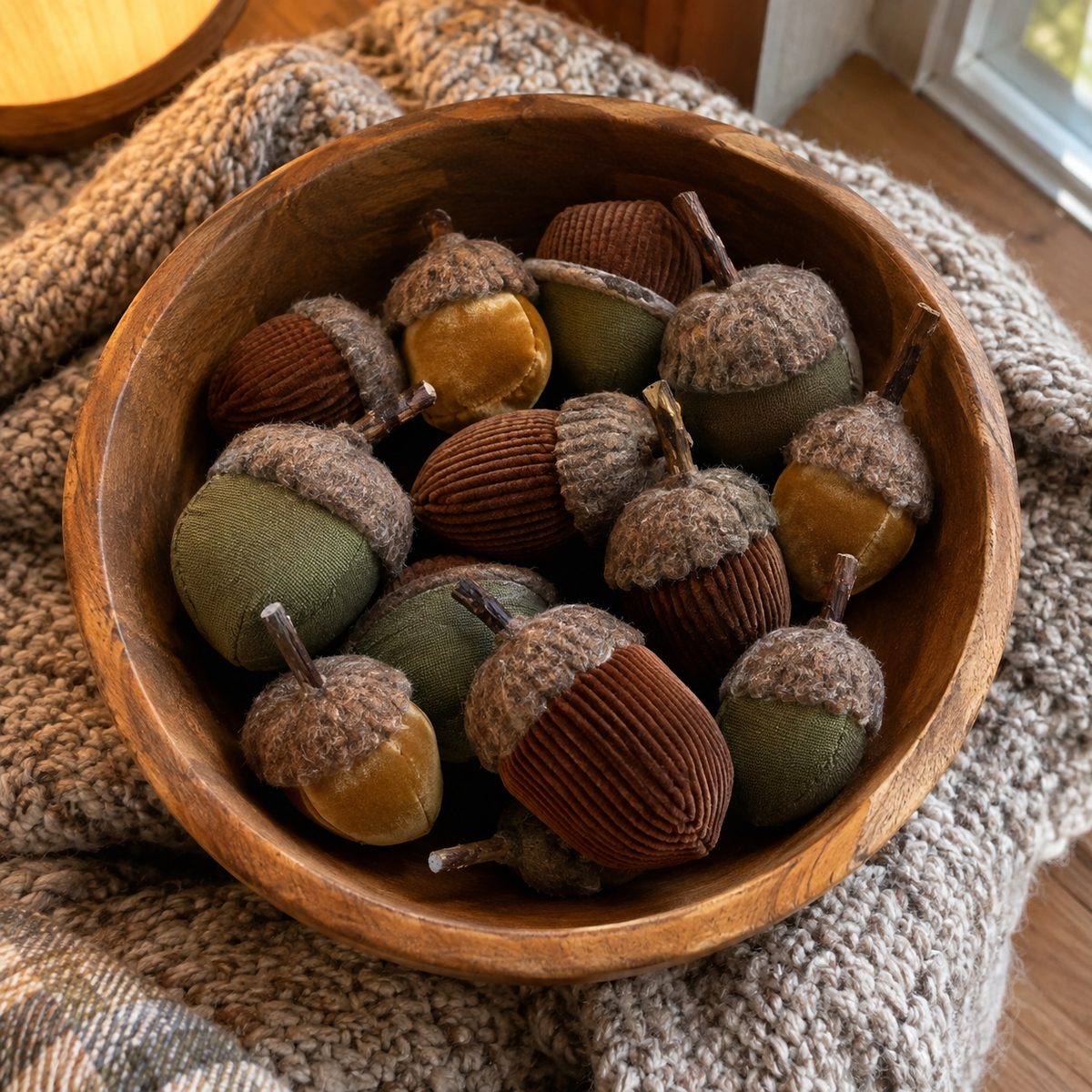 Wooden bowl of handmade fabric acorns with felt caps