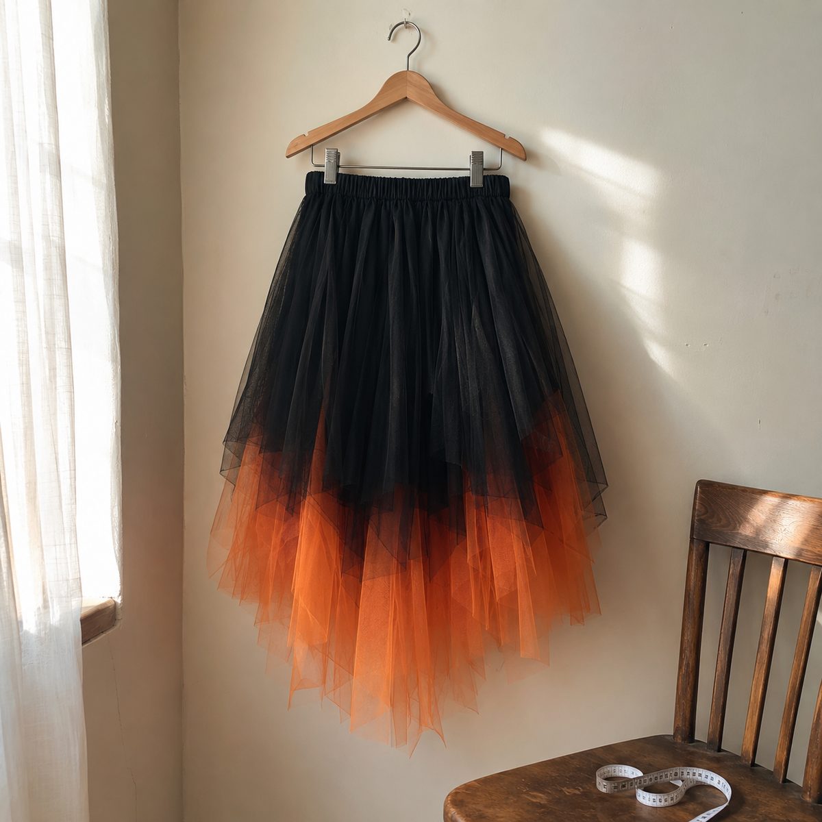 Black and orange layered tulle skirt on a wooden hanger