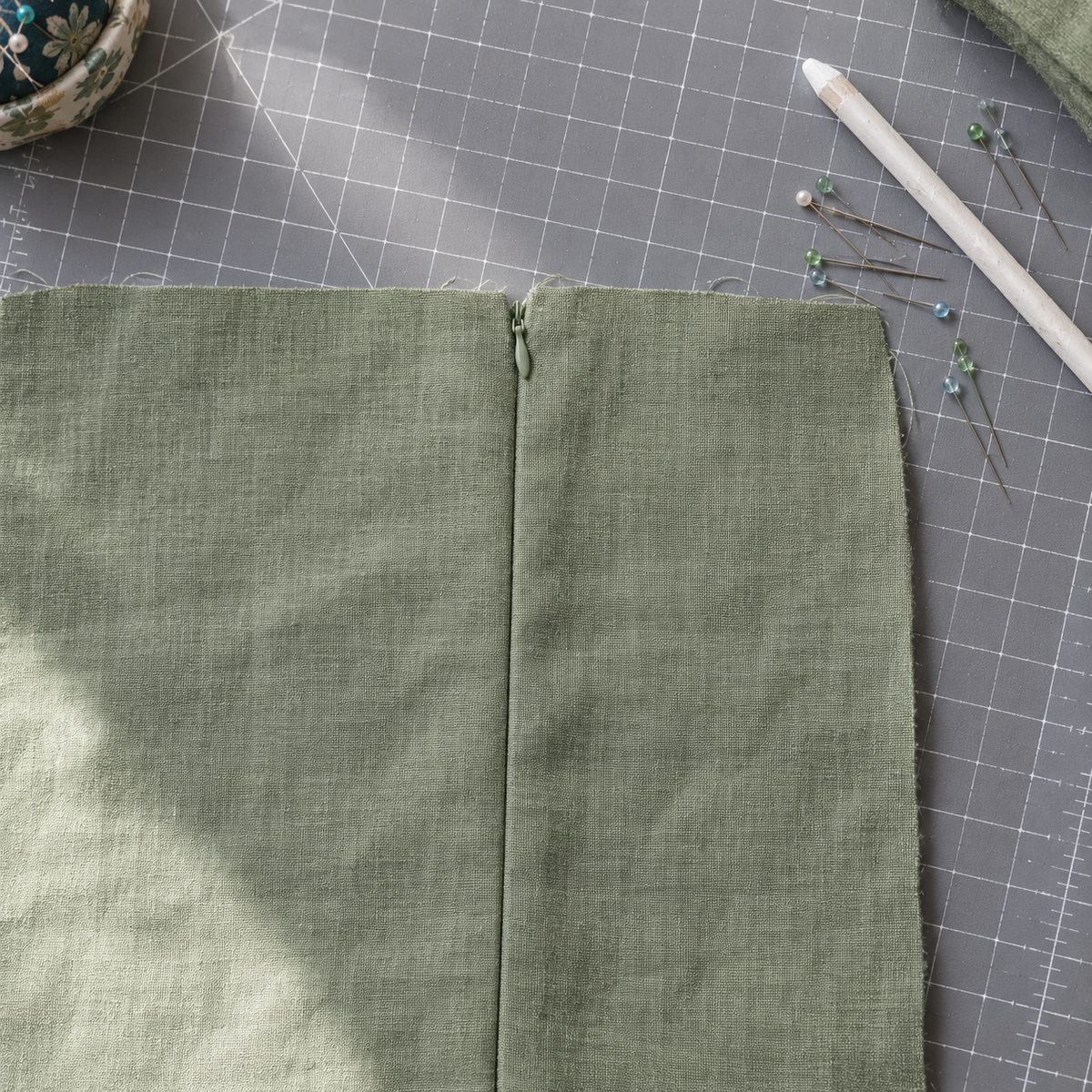 Right side of a closed invisible zipper with the fabric edges meeting over the coil