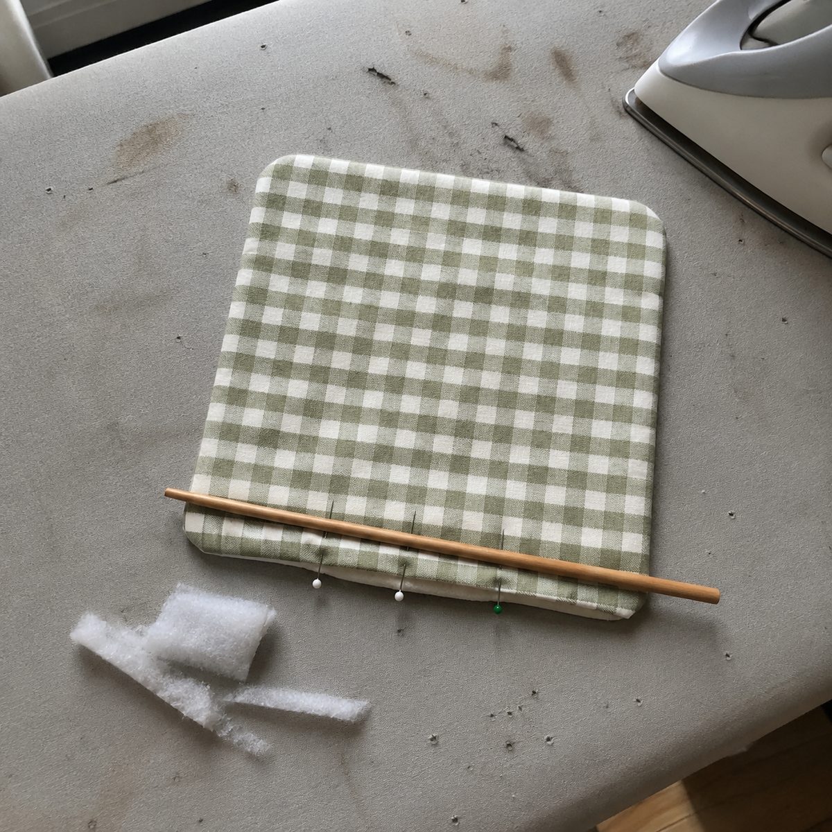 Turned mug rug pressed on an ironing board with the opening pinned ready for topstitching