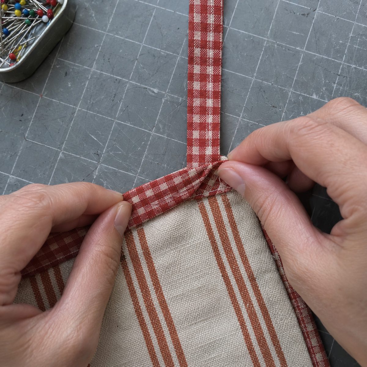 Close-up of folding a binding strip to miter the corner of a mug rug