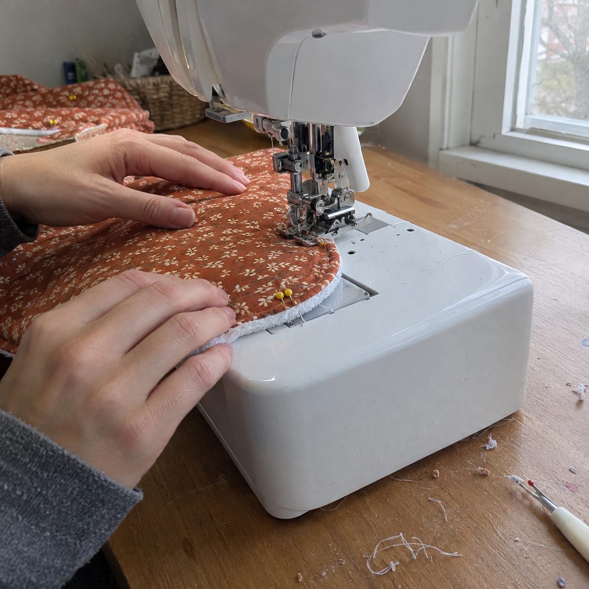 Sewing a pinned flannel and terry burp cloth around the curved end with a walking foot