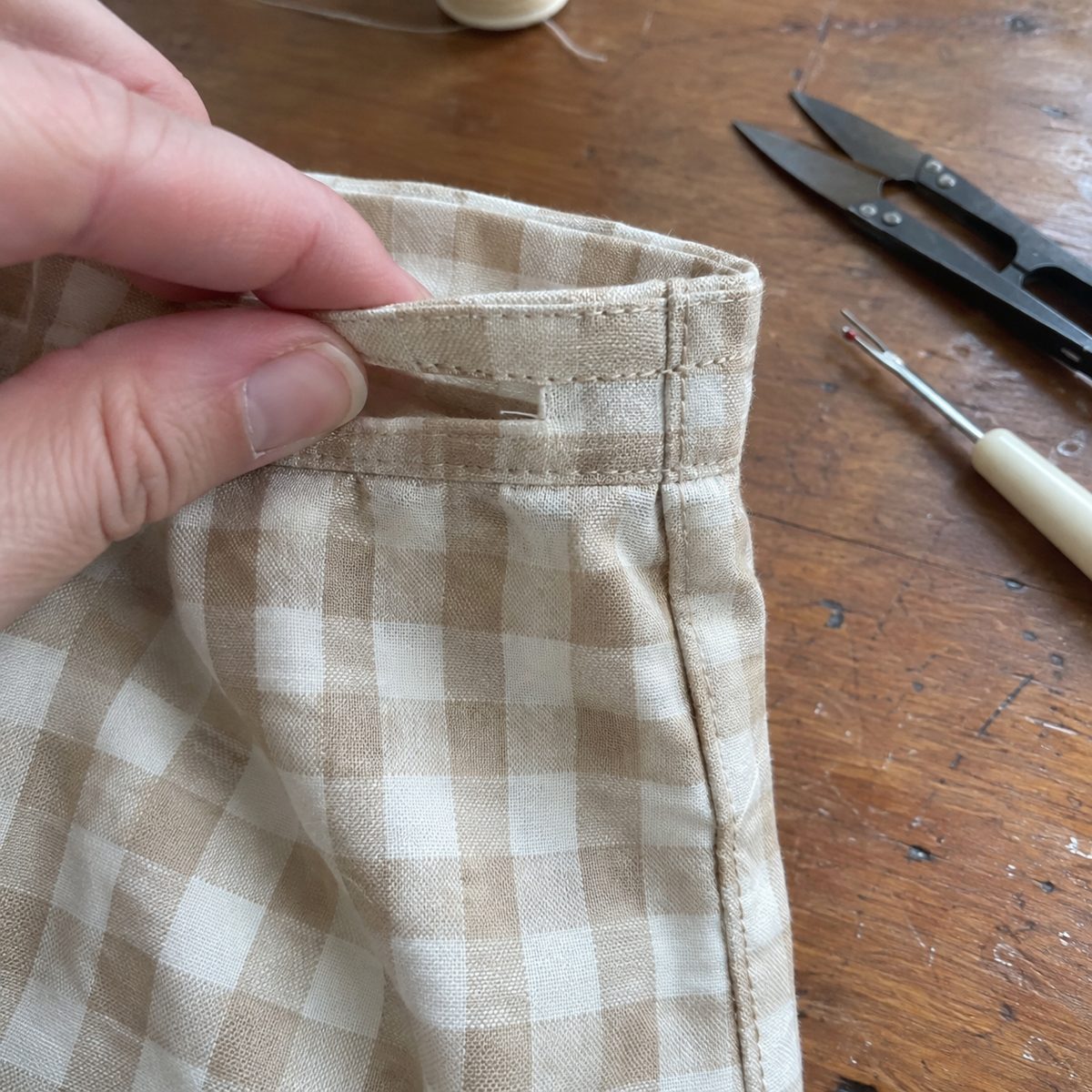 Close-up of the drawstring slot in the stitched casing at the side seam of a fabric gift bag