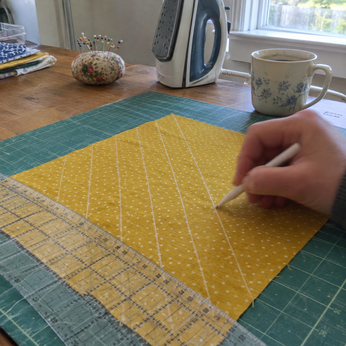 Marking diagonal quilting lines on a pot holder top with chalk and a ruler